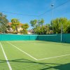 Un campo da tennis con rete e pareti verdi.
