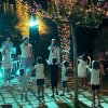 Bambini che ballano in un giardino illuminato.