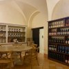 Sala con tavolo rotondo e scaffali di vini.