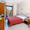 Camera d'hotel con letto matrimoniale, mobili in legno e balcone.