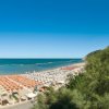 Spiaggia affollata vista dall'alto, vicino a un hotel.