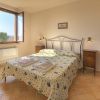 Camera da letto luminosa con letto matrimoniale e finestre aperte.
