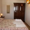 Camera da letto con letto matrimoniale, copriletto floreale, armadio in legno e lampada da comodino.