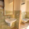 Bagno con lavabo, bidet e water; pareti con piastrelle verde pastello.