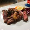 Piatto di carne con contorno di verdure e limone.